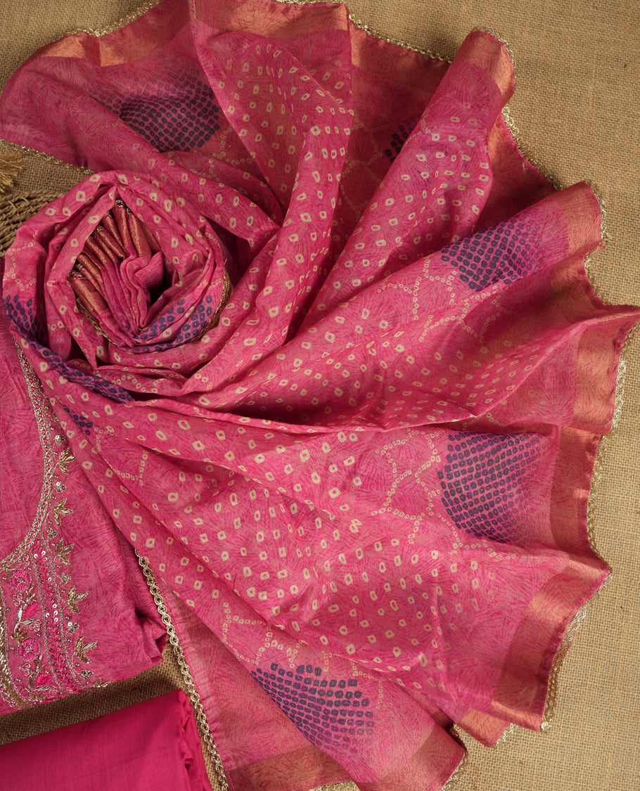 Dark pink colour suit material adorned with pearls, sequins and cut beads embroidery work on the neckline, exuding a graceful charm & Paired with a floral printed dupatta and a matching plain bottom.