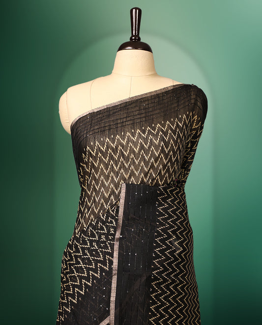 Black colour saree adorned with golden zig zag patterns across the body, complemented by a richly designed traditional pallu, and paired with a matching blouse
