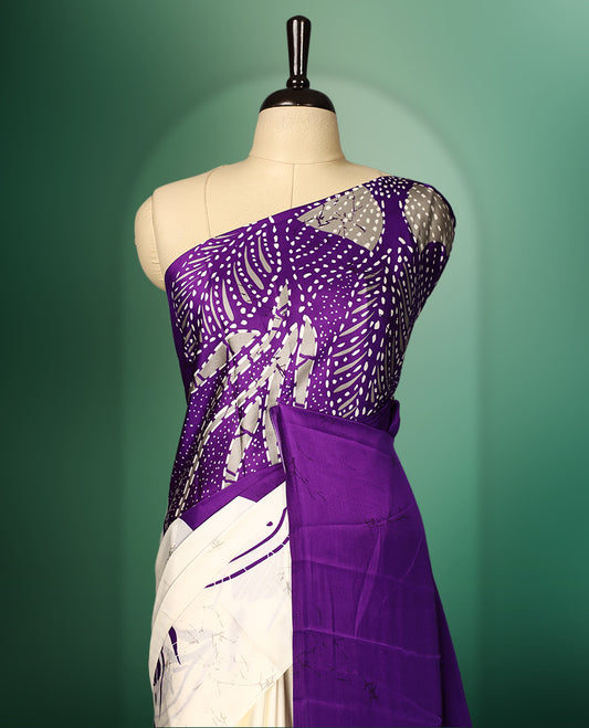 Purple colour Semi Modal saree featuring artistic abstract prints across the body, beautifully contrasted with Off  White highlights, complemented by a bold patterned pallu, and paired with a matching blouse