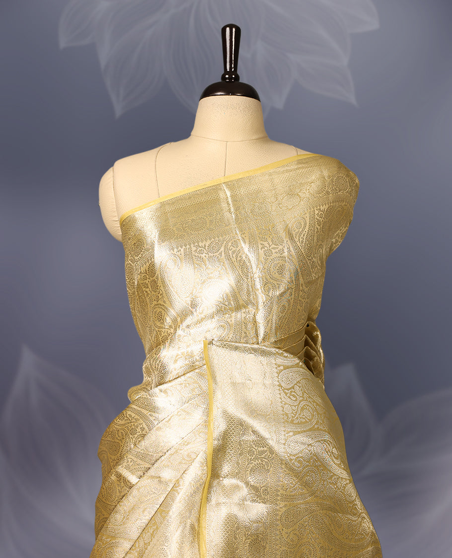 Golden Pure tissue Banaras saree featuring exquisite zari weaving throughout the body with a grand pallu highlighted by bold paisley motifs, making it a luxurious choice for weddings, festive occasions, and grand celebrations