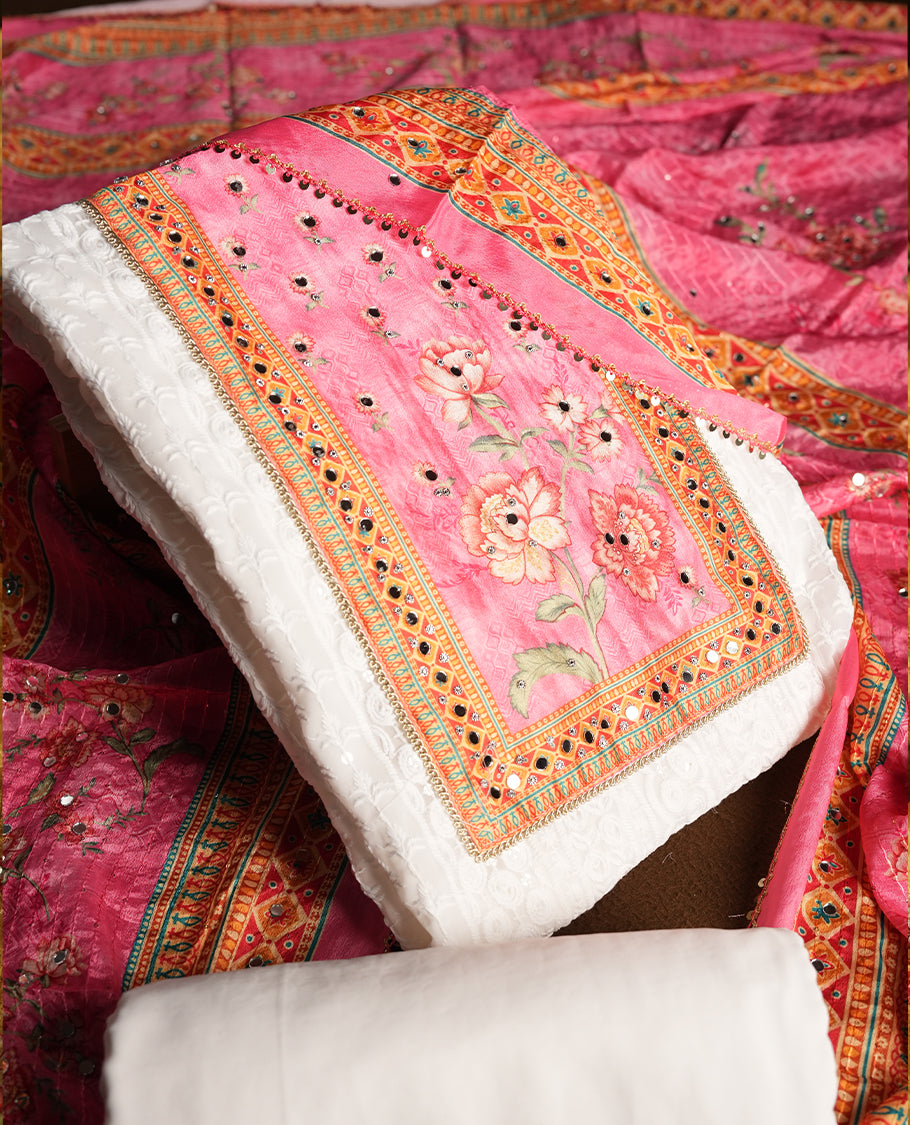 White colour churidhar material featuring Mirror and thread embroidery, foral print pattern on the contrast Pink colour front panel, floral digital printed dupatta with elegant border, and matching plain bottom