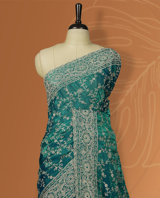 Sky blue colour velvet chiffon designer saree in elegant two tone shades, featuring light gold zari, kodi work with handwoven style thread aari & dori embroidery work, Swarovski stone work and all over motifs, comes with matching blouse.