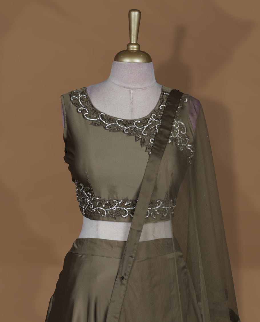 Olive brown colour lehenga set with stitched sleeveless embroidered blouse, matching stitched flared lehenga, and plain sheer dupatta with satin border.