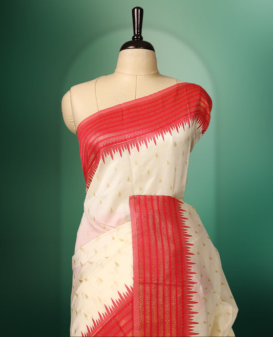 off white colour saree adorned with delicate golden motifs, accentuated by a vibrant red border with intricate weaving, and a rich red gold zari pallu, paired with a matching blouse