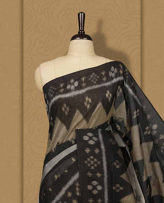 Black colour Ikkat Pochampally saree featuring bold geometric motifs in beige, white, and grey with a striking contrast border, beautifully blending tradition with elegance, Comes with matching blouse.