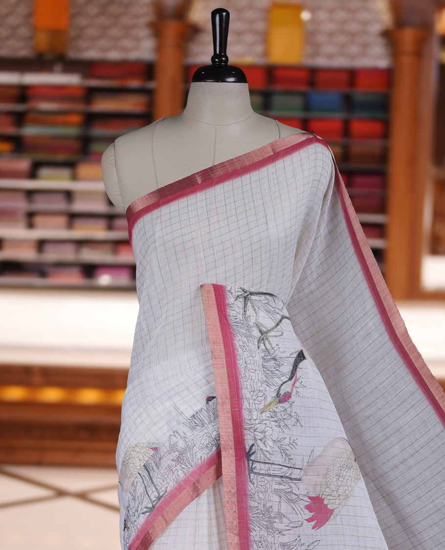 Off white colour Soft cotton saree featuring elegant bird prints along the edges, a stylish checked body, and a beautifully designed pink border & Paired with a matching blouse piece.