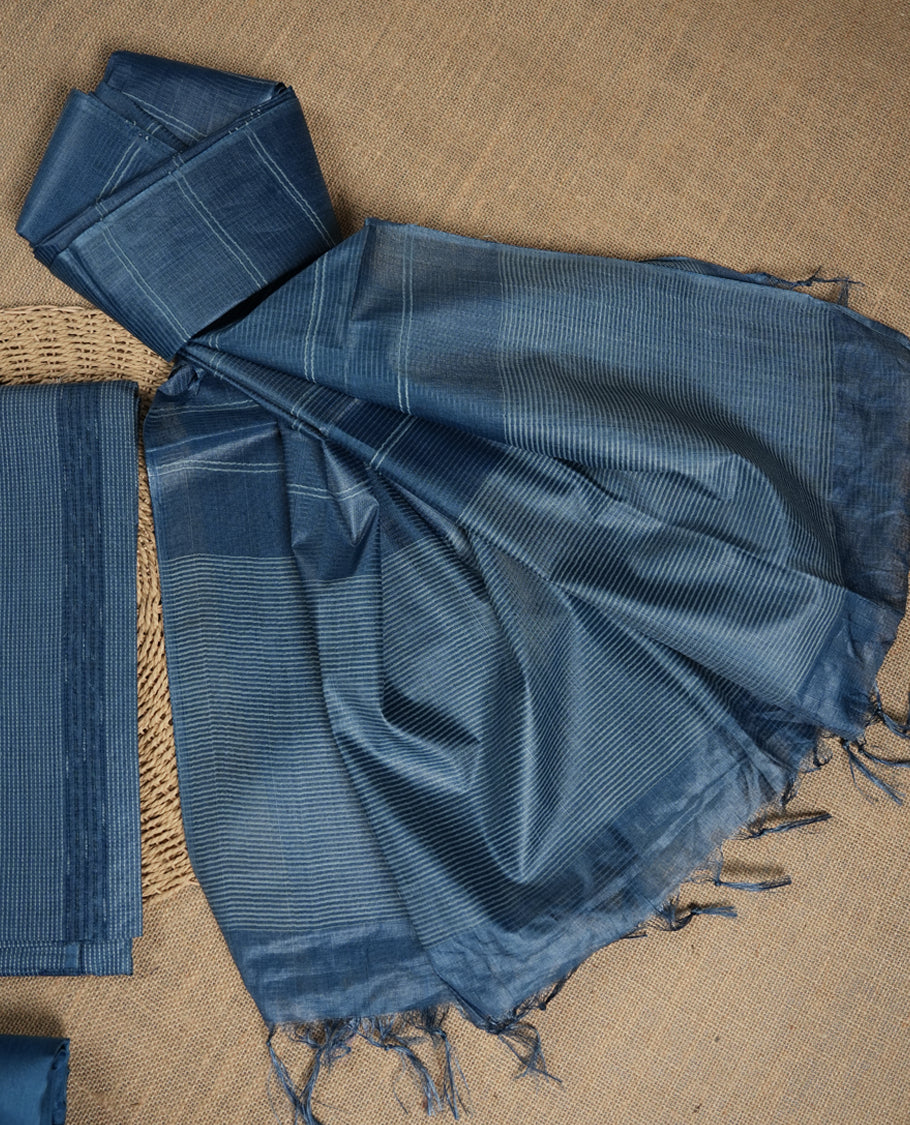 Denim blue colour tussar suit material featuring subtle striped patterns & Includes a soft dupatta with delicate tassels and matching plain fabric for the bottom.