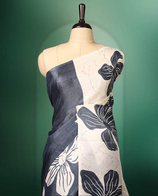 White and grey double shade semi tussar saree adorned with bold floral motifs across the body, designed without a border for a contemporary touch, and paired with a matching blouse