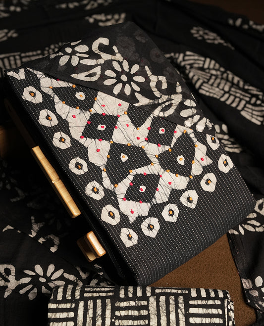 Black & Off white cotton churidar material adorned with thread work on the neckline, featuring traditional tie dye patterns and a stripped body & Comes with a matching printed dupatta and coordinated printed fabric for the bottom.