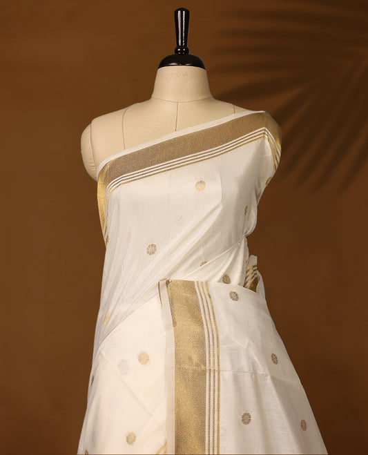 Elegant Kerala Kasavu saree with golden polka motifs and a detailed paisley woven pallu, Finished with tassels, its perfect for festive or traditional wear, Pair with a gold blouse for a classic look.