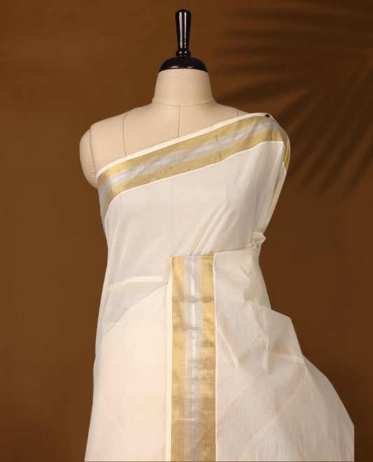 Traditional off white colour cotton Kerala saree featuring a subtle golden and silver dual tone zari border and pallu. Light, elegant, and perfect for festive or cultural occasions, it comes with a matching blouse piece.
