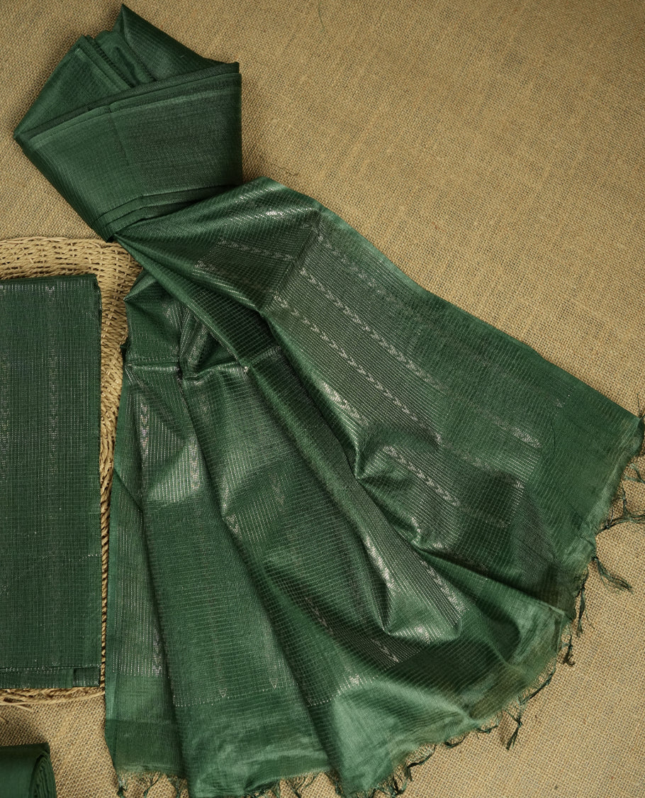 Steel green colour Tussar suit material adorned with intricate silver woven patterns and subtle motifs, exuding ethnic elegance & Paired with a beautifully bordered dupatta and a matching plain bottom.