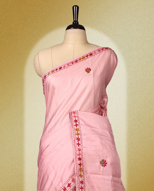 Pink colour pure tussar saree adorned with delicate multicolour floral embroidery along the border and scattered motifs across the body, paired with a matching blouse.