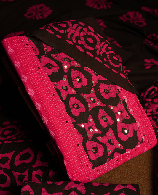 Black and magenta colour cotton churidar material featuring mirror work on the neckline with traditional tie dye patterns & Paired with a matching printed dupatta and coordinated printed fabric for the bottom.