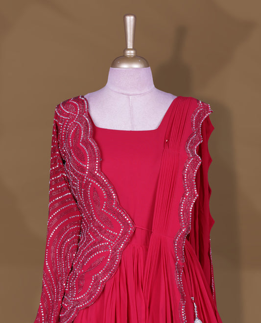 Rani pink colour stitched gown set with square neckline, attached pleated flare, and one‑side draped dupatta highlighted with heavy silver sequin and mirror work border and sleeve.