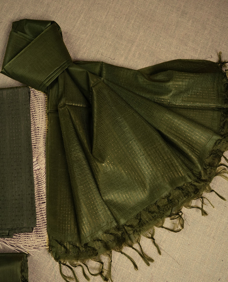 Dark Army green colour tussar suit material featuring a subtle self copper zari woven motifs and vertical and stripped pattern on the body, paired with a lightweight matching dupatta with tassel edges and a plain bottom piece.