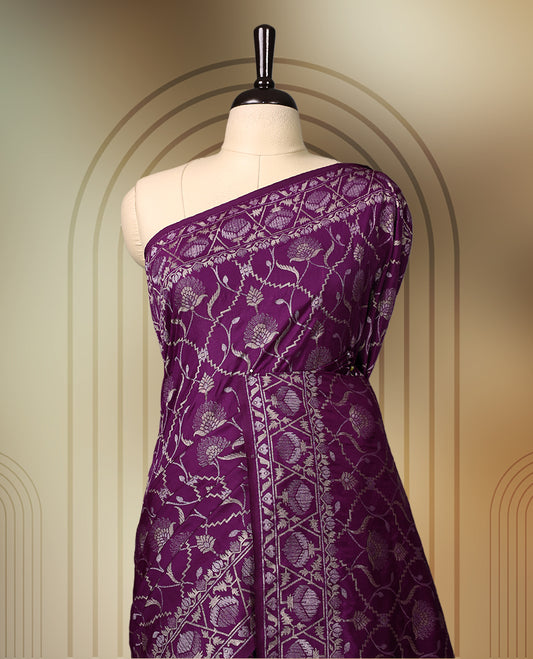 Rich purple Banaras soft silk saree with all over silver zari floral vines, ornate woven border, and bold pallu with paisley motifs. Comes with a matching blouse & Ideal for weddings and festive occasions.