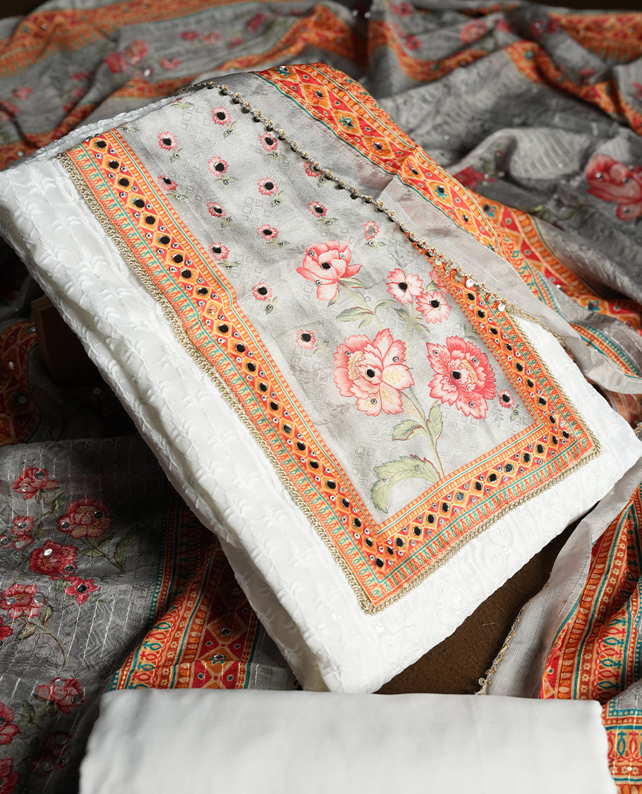 White colour churidhar material featuring Mirror and thread embroidery & foral print pattern on the contrast ash colour front panel, floral digital printed dupatta with elegant border, and matching plain bottom