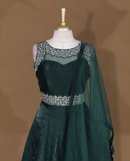 Emerald green colour Gown with stitched sleeveless blouse featuring embellished neckline and waist detailing, paired with a matching stitched flared lehenga and sheer dupatta.