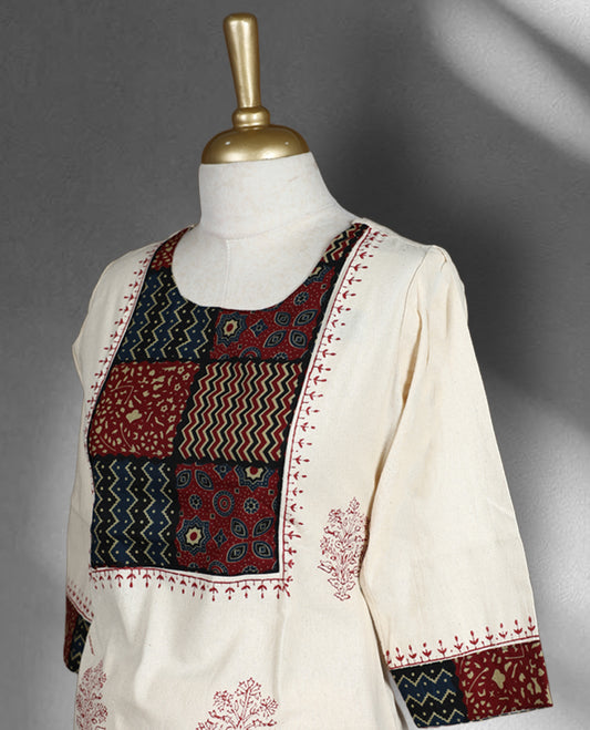 Cream colour cotton cord set with maroon floral prints, highlighted by vibrant patchwork on the yoke and sleeve borders, Paired with matching straight pants.
