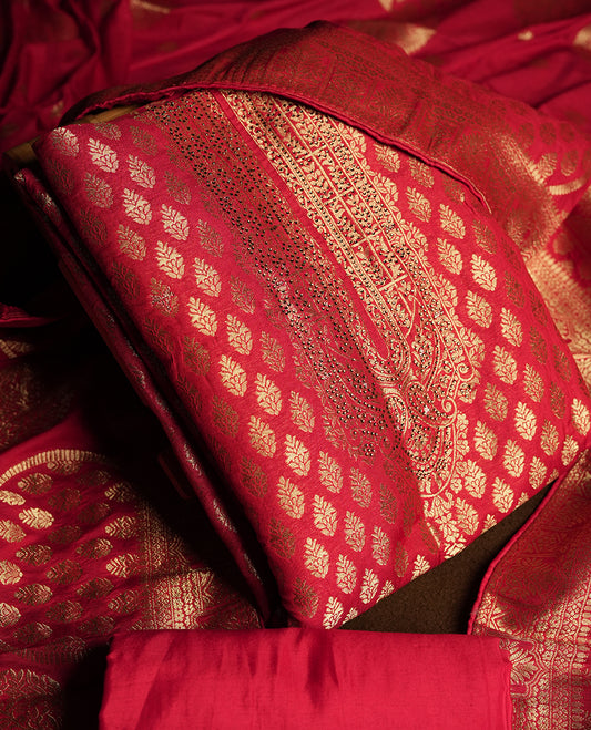 Maroon colour churidar material adorned with delicate golden stone work on the neckline, featuring zari leaf motifs across the body & Comes with a rich zari woven dupatta and a matching plain bottom.