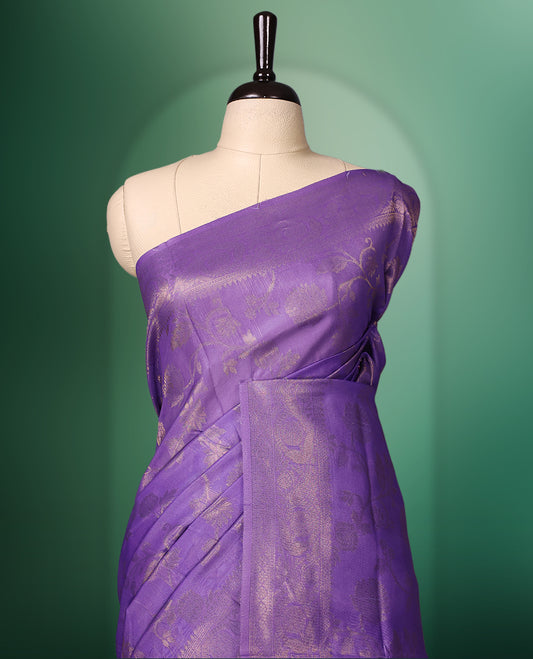 Lavender colour saree featuring subtle woven floral motifs with a lustrous finish, complemented by delicate tassels on the pallu, and paired with a matching blouse
