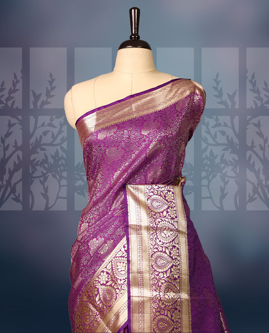 Purple semi silk brocade saree with rich gold zari brocade work all over, complemented by an intricately woven gold border and pallu, Comes with a matching blouse for a grand traditional look.