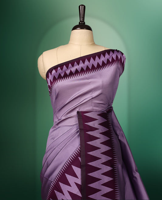 Lavender colour saree accentuated with bold deep purple zigzag woven borders and a contrasting rich copper zari pallu, paired with a matching blouse