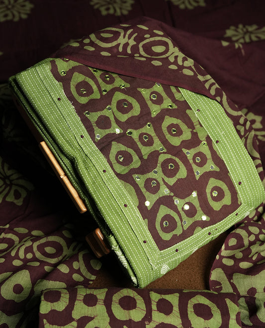 Green and Brown colour cotton churidar material adorned with mirror work on the neckline, featuring traditional tie dye patterns & Comes with a matching printed dupatta and coordinated printed bottom.