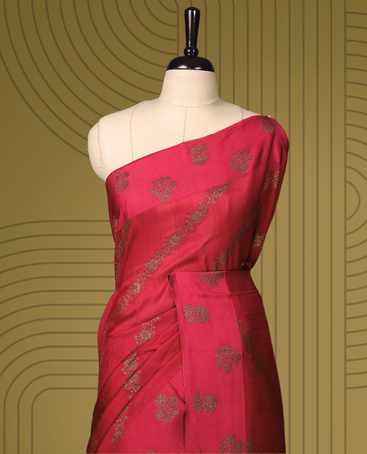 Rani pink semi Banaras tussar saree adorned with golden floral motifs in diagonal patterns across the body and a beautifully woven zari border, finished with a rich golden pallu, paired with a matching blouse.