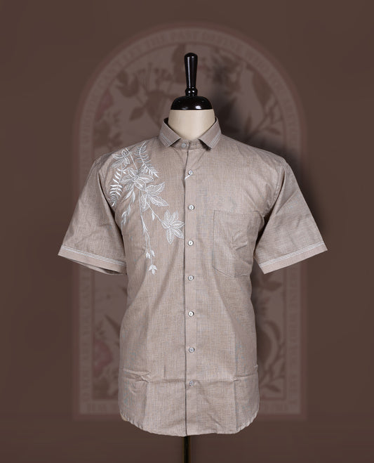 Taupe colour cotton linen short sleeve shirt featuring delicate white floral embroidery on the shoulder, Designed with a classic collar and button down front, offering a stylish blend of comfort and elegance.