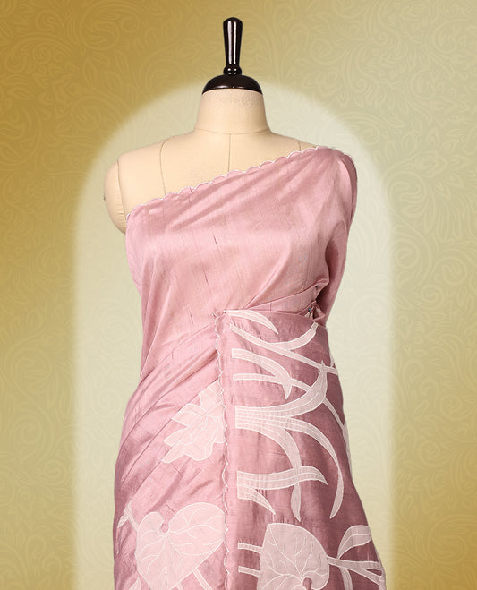 pink colour semi tussar saree featuring elegant white floral and leaf applique work along the body and border, paired with a matching blouse.