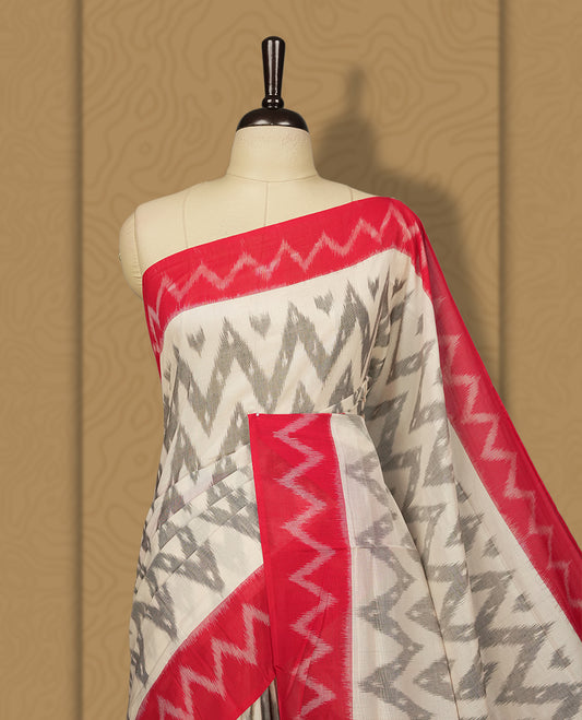 Off white colour Ikkat Pochampally saree with bold grey colour zigzag motifs and contrasting maroon borders, The striking woven pallu enhances its elegance, making it a perfect blend of tradition and style, Paired with a matching blouse.