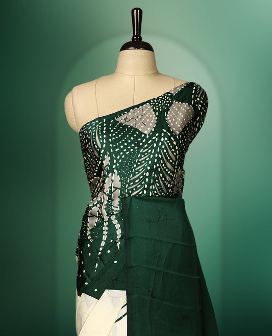 Dark Green colour Semi Modal saree featuring artistic abstract prints across the body, beautifully contrasted with Off  White highlights, complemented by a bold patterned pallu, and paired with a matching blouse