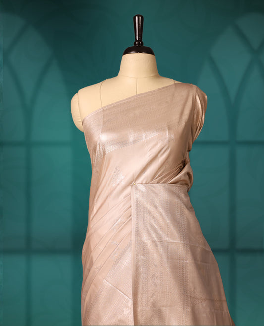 Beige colour semi silk saree featuring a plain lustrous body, complemented by a rich self colour woven border and pallu, paired with a matching blouse.