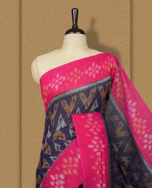 Navy blue colour Ikkat Pochampally saree featuring a vibrant magenta pink border and pallu adorned with traditional ikat motifs in shades of beige & grey, bringing a perfect blend of heritage and modern charm, Comes with matching blouse.