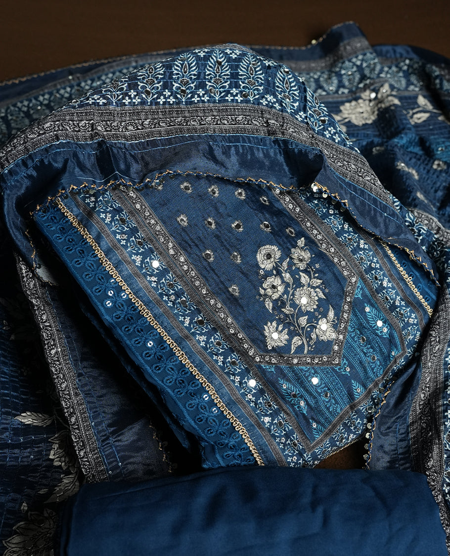 Dark Blue colour churidhar material featuring Mirror and thread embroidery, foral print pattern on the self colour front panel, floral digital printed dupatta with elegant border, and matching plain bottom