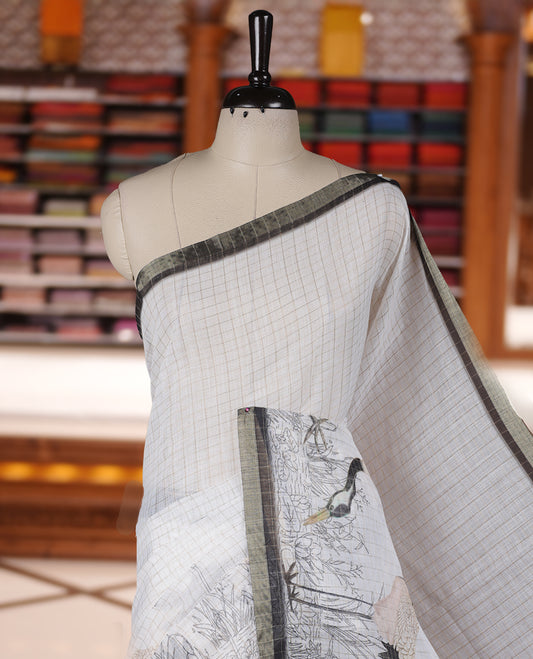 Off white colour Soft cotton saree featuring elegant bird prints along the edges, a stylish checked body, and a beautifully designed black border & Paired with a matching blouse piece.