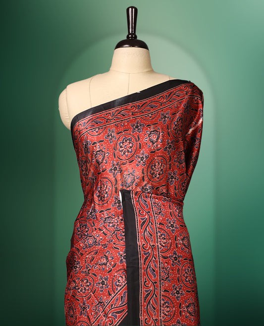 Red colour semi modal saree adorned with intricate all over traditional motifs in black and gold, enhanced by a rich patterned pallu and black border, paired with a matching blouse