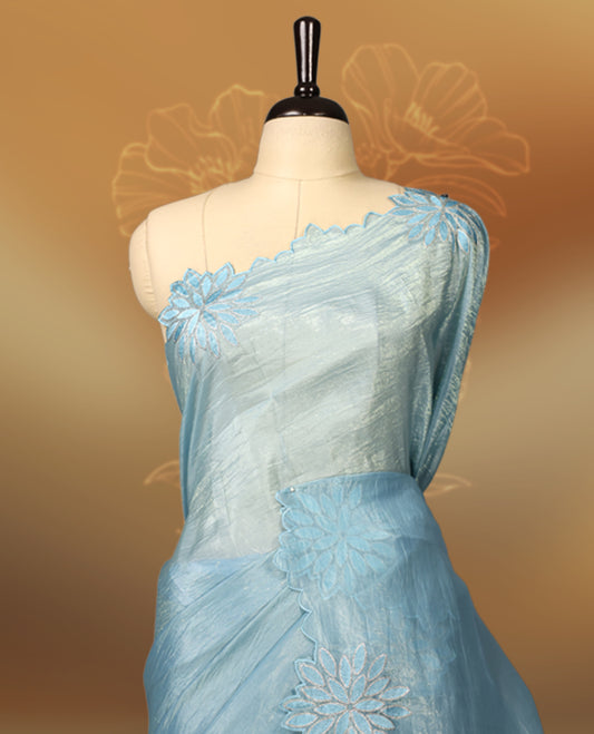 Pastel Blue colour crush soft silk saree adorned with bold floral thread embroidery on the body and scallop edged borders, Paired with a matching blouse for a complete look.
