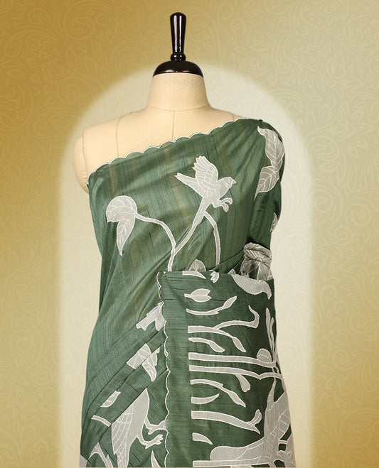 Green colour semi tussar saree adorned with elegant white applique work in leaf and floral designs across the body and border, paired with a matching blouse.