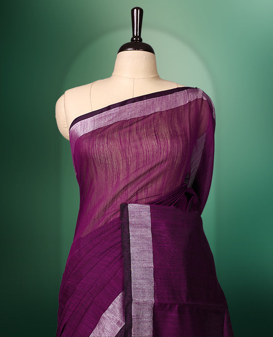 Deep plum colour handloom cotton saree featuring a solid body with a contrasting silver zari border and subtle striped pallu, paired with a matching blouse