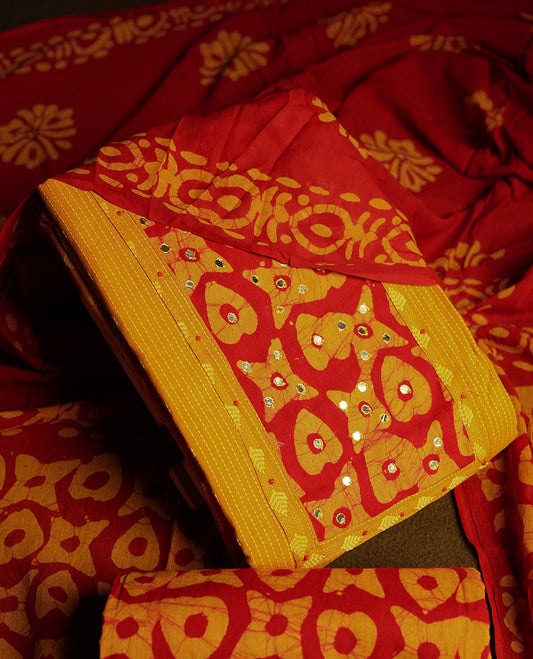 Maroon and Yellow cotton churidar material adorned with mirror work on the neckline, featuring traditional tie dye patterns & Comes with a matching printed dupatta and coordinated printed fabric for the bottom.