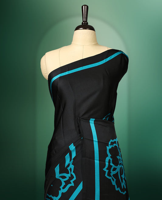 Black colour saree adorned with bold Light Blue floral motifs and matching border accents, paired with a coordinating blouse