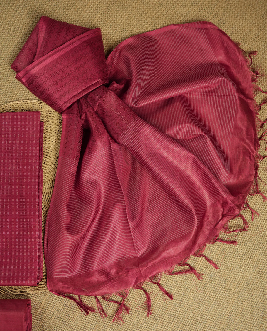 Light Maroon colour tussar suit material adorned with intricate woven patterns and subtle motifs, exuding ethnic elegance & Paired with a beautifully bordered dupatta and a matching plain bottom.