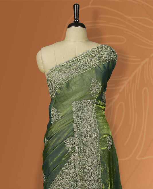 Asparagus green colour velvet chiffon designer saree in elegant two tone shades, featuring light gold zari, kodi work with handwoven style thread aari & dori embroidery work, Swarovski stone work and all over motifs, comes with matching blouse.