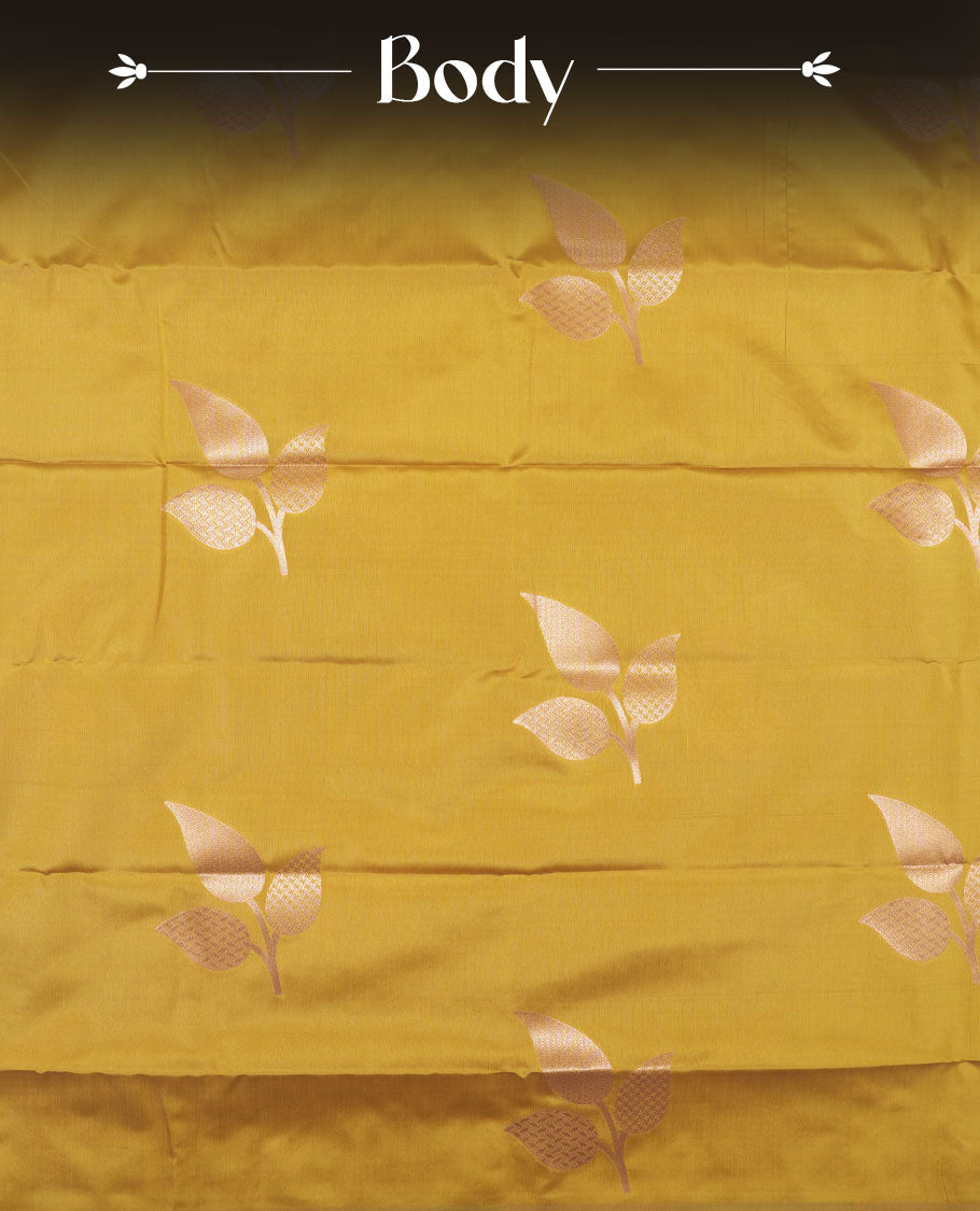 Mustard yellow colour semi silk saree adorned with elegant leaf motifs on the body, complemented by a shimmering golden zari woven pallu and border, and paired with a matching blouse