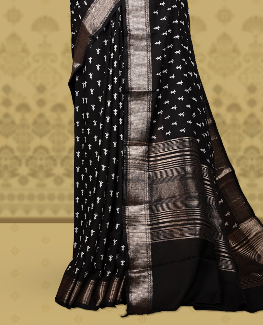 Black colour saree adorned with elegant white floral prints and a rich black zari border and rich stripped pallu & Comes with a matching blouse piece.