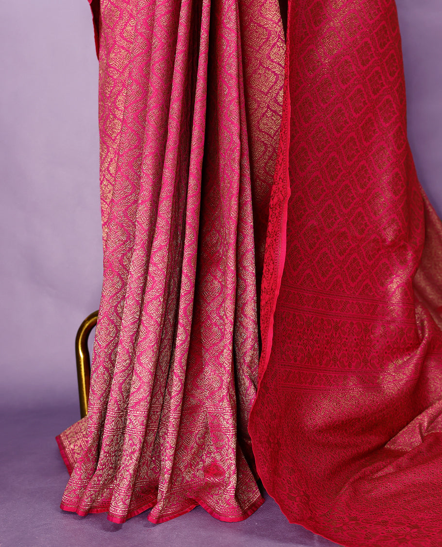 Magenta colour semi Banaras Katan saree featuring an antique Gold zari jacquard body, complemented by a self colour traditional border with a floral kodi design, paired with a matching blouse