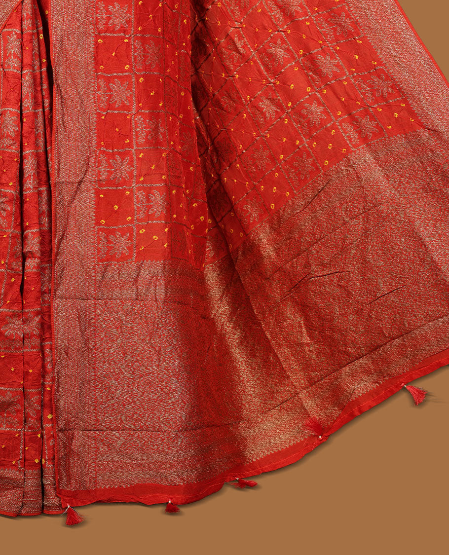 Reddish orange colour Banarasi Bandhani silk saree featuring with intricate Banarasi motifs on body, complemented by antique zari woven border and grand pallu, paired with matching  blouse